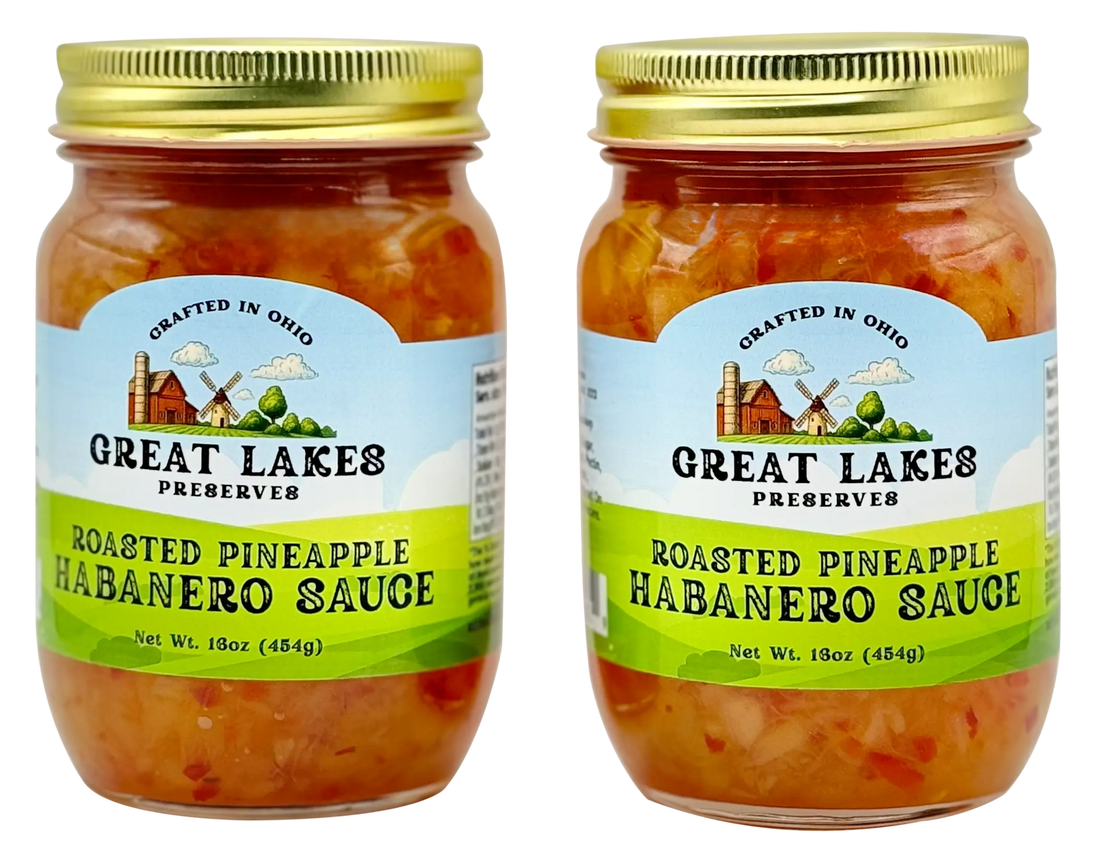 Two Great Lakes Preserves Roasted Pineapple Habanero Sauce jars with gold lids, front labels facing.